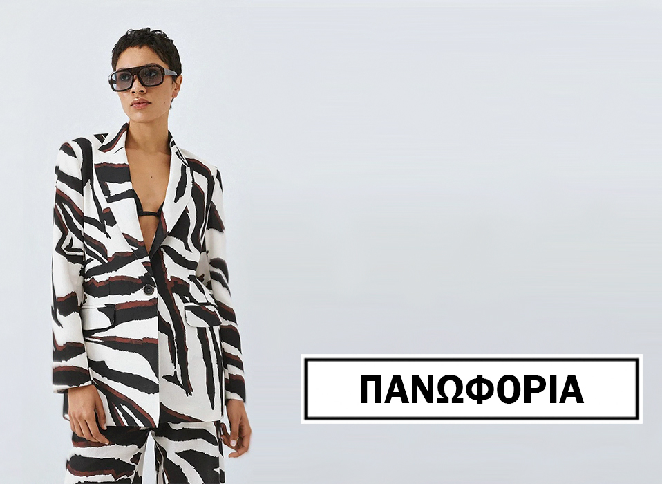 Woman model in a black and white zebra print suit with sunglasses standing against a light background brand name Πανφορία shown in a bordered box to the right