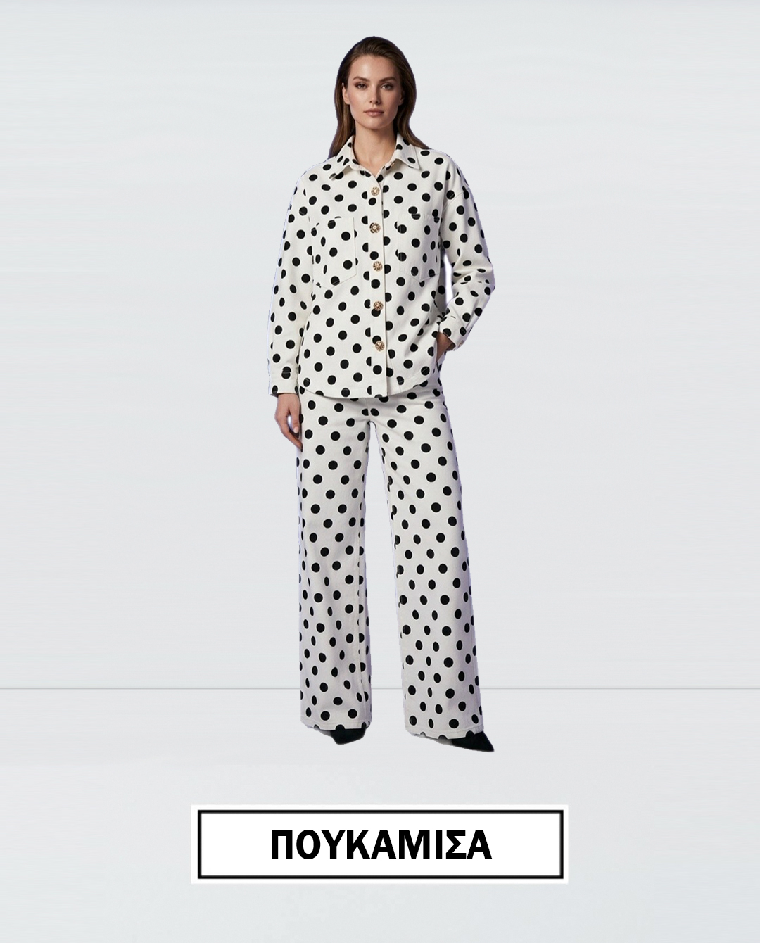 Model wearing a white polka dot pajama set button up top and wide leg pants with black spots Greek label ΠΟΥΚΑΜΙΣΑ shown below